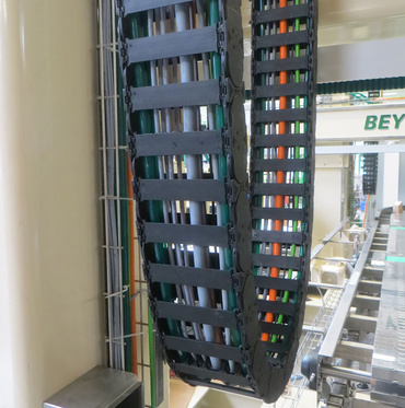 Chaîne porte-câbles suspendue dans un palettiseur