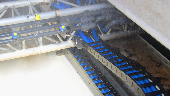 Chaîne porte-câbles avec tuyaux transportant des agents